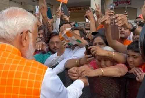 Woman ties rakhi to PM Modi as huge crowd gathers outside polling booth in Ahmedabad